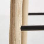 Detailansicht des Gestells des Design Tresenstuhls MONO von WOUD in Eiche, weißpigmentiert lackiert mit schwarzen Fußstützen Detail Gestell Tresenstuhl mit Lehne aus Holz in Eiche - MONO von WOUD