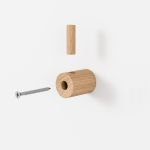 Der kleine Wandhaken WOODEN WALL HOOK von MOEBE besteht aus zwei Teilen: der Größere wird mittels einer Schraube an der Wand befestigt, der Kleinere von oben in das Loch gesteckt, um die Schraube zu verdecken kleine Wandhaken aus Holz - Wooden Wall Hook von Moebe