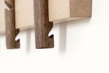Am unteren Ende eines jeden Hakens der Garderobenleiste RECES von Roon & Rahn befindet sich eine zusätzliche Kerbe, in die bei Bedarf ein schmaler Kleiderbügen eingehängt werden kann Detail der Haken der Garderobenleiste aus Eiche - RECES von Roon & Rahn