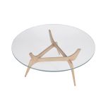 Die runde Glasplatte des TRIIIO COFFEE TABLE von Brdr. Krüger wird von eine eleganten Massivholzgestell getragen runder Couchtisch aus Massivholz Eiche und Glas transparent - TRIIIO von Brdr. Krüger