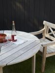 Die lebendige Maserung des Holzes ist deutlich auf der Oberfläche des Gartentisches sichtbar und unterstreicht den natürlichen Charakter runder Teakholz Gartentisch für 4 Personen - DRACHMANN TABLE von Skagerak