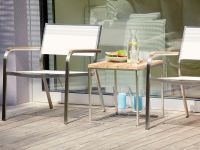 Der moderne Beistelltisch LUX aus Teakholz und Edelstahl von Jan Kurtz bietet eine stilvolle Ablage für Getränke und persönliche Gegenstände moderner Beistelltisch aus Holz in Teak und Edelstahl - LUX von Jan Kurtz