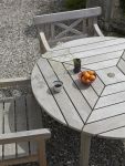 Mit der Zeit entwickelt Teak zum eigenen Schutz eine silbergraue Patina, der man nach Wunsch mit entsprechenden Pflegeprodukten entgegenwirken kann runder Gartentisch aus Teakholz im dänischen Design - DRACHMANN TABLE von Skagerak