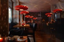 Die Designerlampen TR5 aus rot gebeiztem Birkenholzfurnier sind als indirekte Lichtquelle im Restaurant ein echter Blickfänger Designer Pendelleuchte mit Birkenfurnier in rot TR5 von Tom Rossau