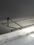 Detailansicht der gut durchdacht gestalteten Garderobe SHOE RACK mit einer Wandhalterung aus Schwarzstahl Hängendes Schuhregal in Eiche geräuchert SHOE RACK von We Do Wood