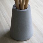 Nahaufnahme des Garderobenständers SPAGHETTI COAT RACK von EKTA LIVING mit Standfuß aus Beton Nahaufnahme von Garderobenständer aus Buche und Beton - SPAGHETTI COAT RACK von Ekta Living