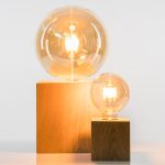 Tischlampe QUADER von Raumgestalt mit Glühbirne und einem quadratischen Holzfuß in zwei verschiedenen Größen QUADER von Raumgestalt - Tischlampe mit Glühbirne und quadratischem Holzfuß beide Größen