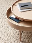 Detailaufnahme des Sofatischs TURNING TABLE in Eiche weiß von Audo Copenhagen mit verstecktem Stauraum zur Ablage persönlicher Gegenstände MENU - TURNING TABLE runder Couchtisch mit Stauraum aus Holz in Eiche weiß