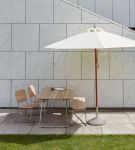 Einladende Outdoor-Sitzgruppe mit dem Gartenmöbelset LILIUM und dem Sonnenschirm MESSINA von Skagerak by Fritz Hansen Skagerak LILIUM modernes Gartenmöbelset für vier Personen aus Holz und Metall