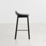 Seitenansicht des Design Tresenstuhls MONO mit Lehne von WOUD in Eiche, schwarz lackiert Seitenansicht Tresenstuhl aus Holz in Eiche schwarz mit Lehne - MONO von WOUD